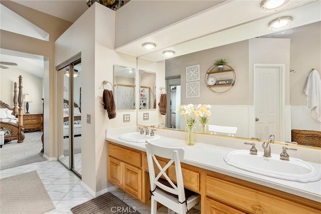 bathroom featuring tile patterned flooring, lofted ceiling, and vanity