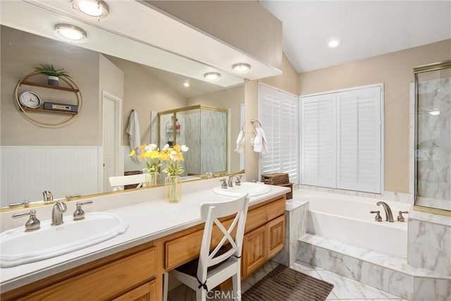 bathroom with vanity, independent shower and bath, and vaulted ceiling