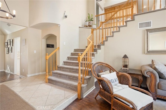 stairs featuring a chandelier and tile patterned floors