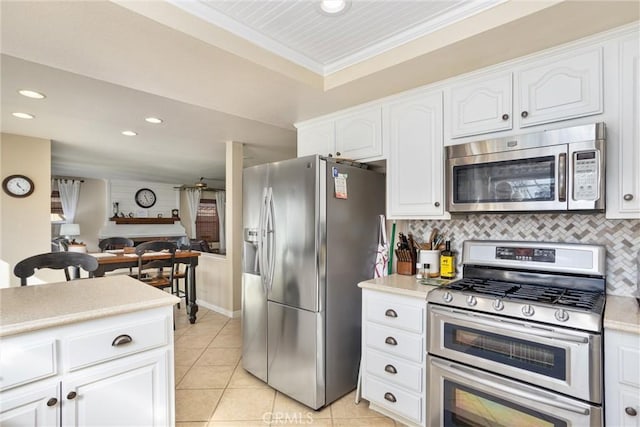 kitchen featuring decorative backsplash, appliances with stainless steel finishes, white cabinetry, and ornamental molding