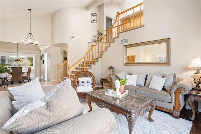 living room featuring a chandelier, beam ceiling, hardwood / wood-style floors, and high vaulted ceiling