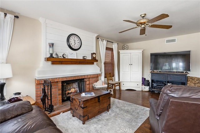 living room featuring ceiling fan, a fireplace, and hardwood / wood-style floors