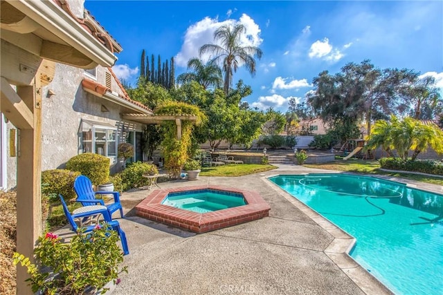 view of swimming pool with an in ground hot tub and a patio area