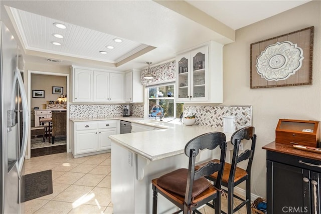 kitchen with white cabinetry, appliances with stainless steel finishes, kitchen peninsula, and hanging light fixtures