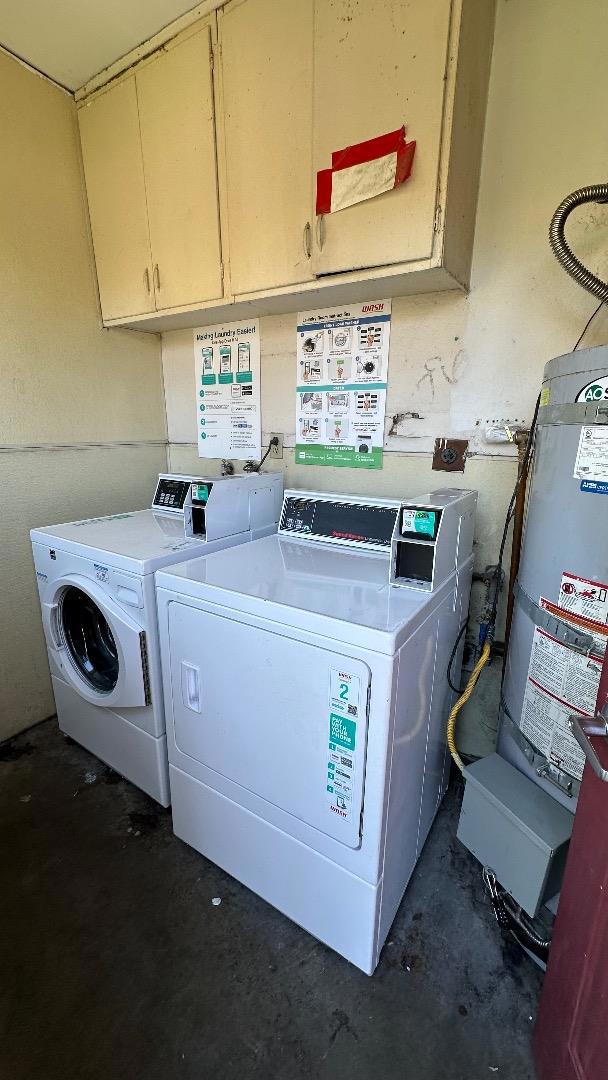 laundry area featuring water heater and separate washer and dryer