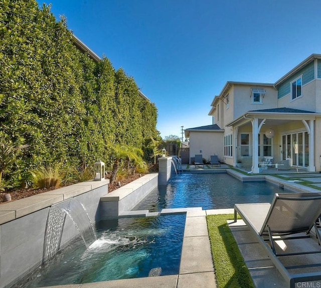 view of pool featuring pool water feature and a patio