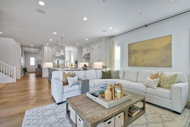 living room with light wood-type flooring and sink