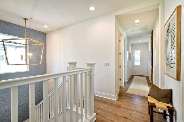 hallway featuring wood-type flooring and a notable chandelier