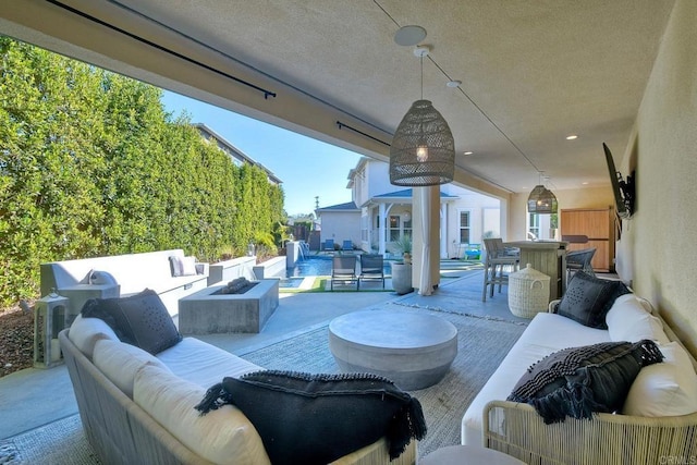 view of patio with an outdoor living space with a fire pit and a pool