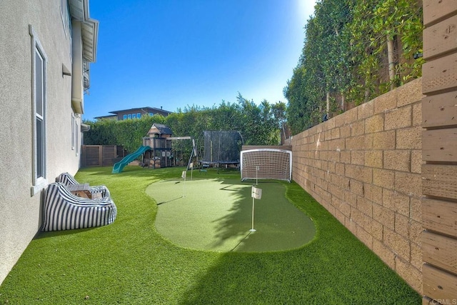 view of yard featuring a trampoline and a playground