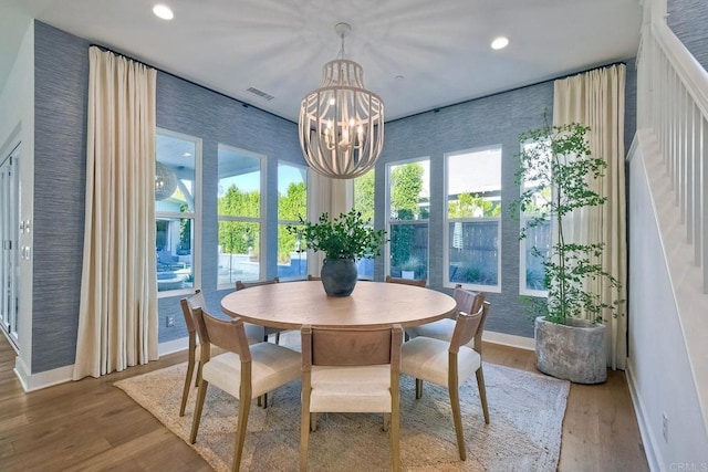 dining room with hardwood / wood-style flooring and a notable chandelier