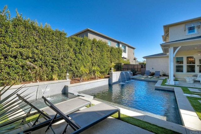 view of swimming pool with pool water feature and a patio