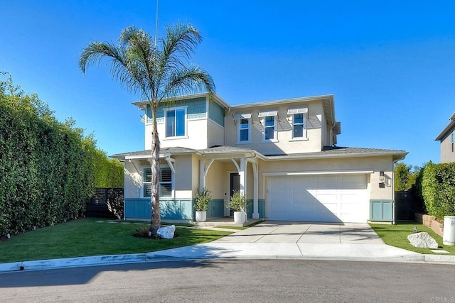 view of front of house with stucco siding, driveway, an attached garage, and a front yard