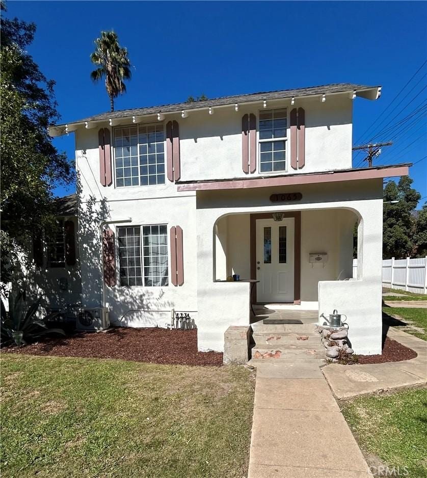 view of front of home with covered porch and a front yard