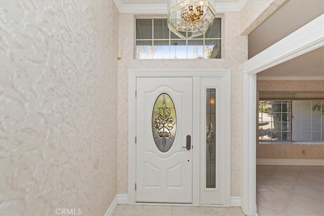 entryway featuring an inviting chandelier, light tile patterned flooring, and ornamental molding