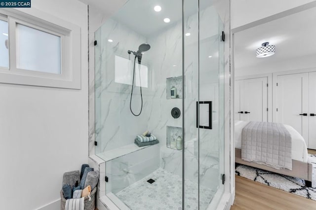 bathroom with an enclosed shower and hardwood / wood-style floors