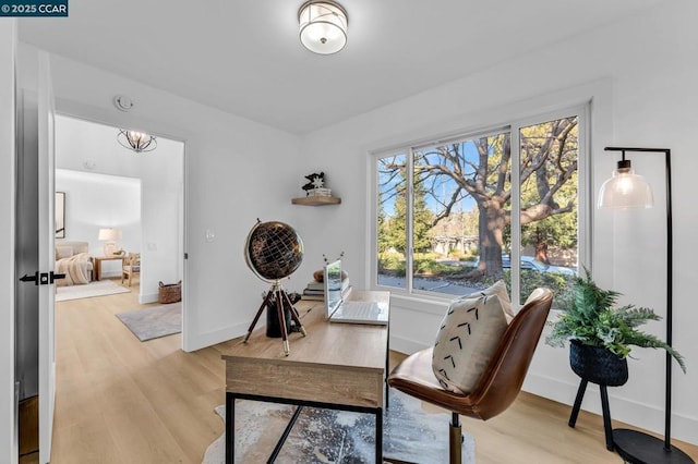 office area with an inviting chandelier and light hardwood / wood-style flooring