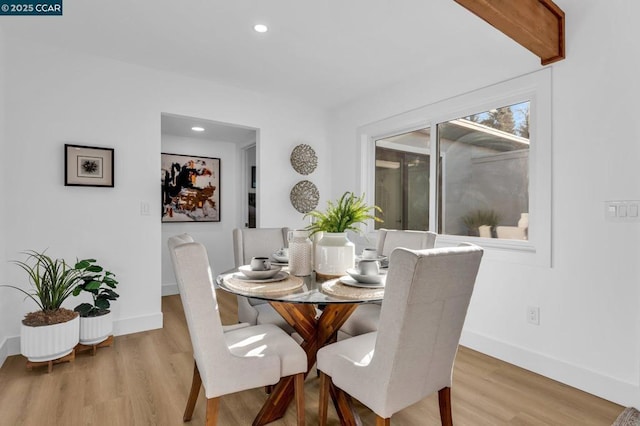 dining room featuring beam ceiling and hardwood / wood-style floors