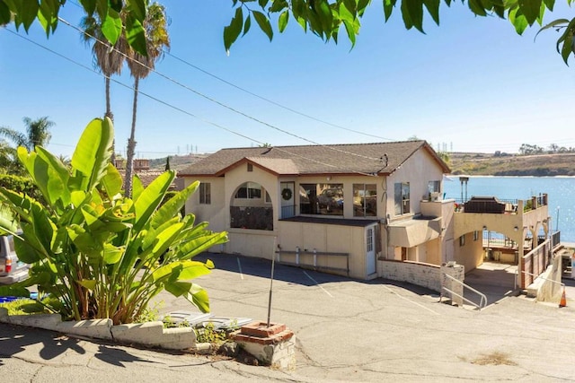 view of front of property with a water view and a patio area