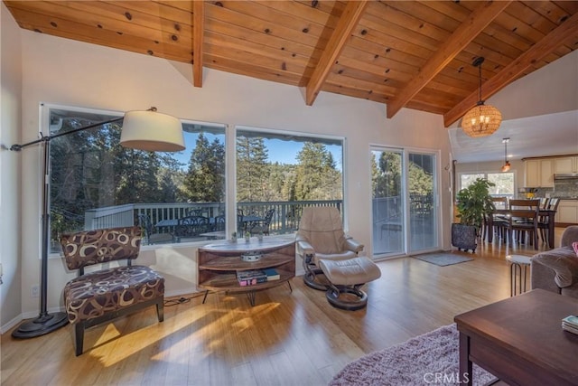 living room with a notable chandelier, light hardwood / wood-style floors, beamed ceiling, wood ceiling, and high vaulted ceiling