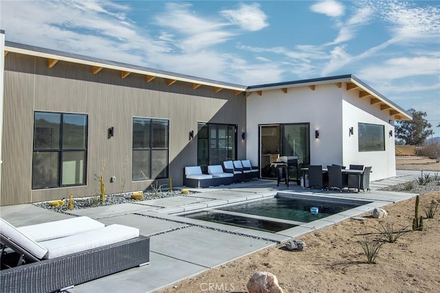 rear view of house with outdoor lounge area and a patio