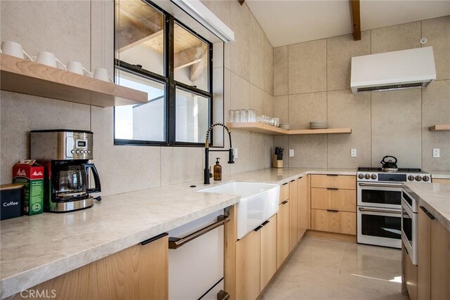 kitchen featuring light brown cabinetry, sink, tasteful backsplash, range with two ovens, and exhaust hood