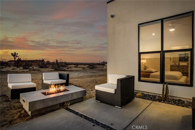 patio terrace at dusk featuring an outdoor fire pit