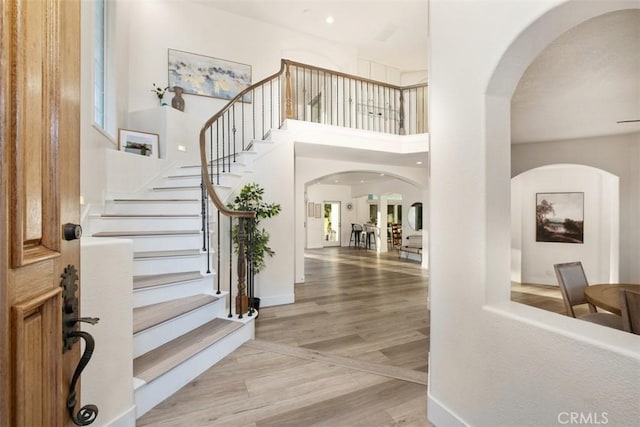 foyer with a high ceiling and light hardwood / wood-style floors