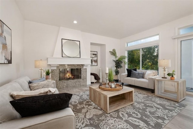 living room with a wealth of natural light, a fireplace, and light hardwood / wood-style floors