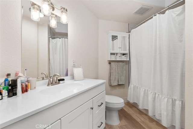 bathroom with walk in shower, vanity, toilet, and hardwood / wood-style floors