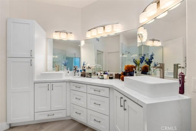 bathroom with vanity, a shower with shower door, and wood-type flooring