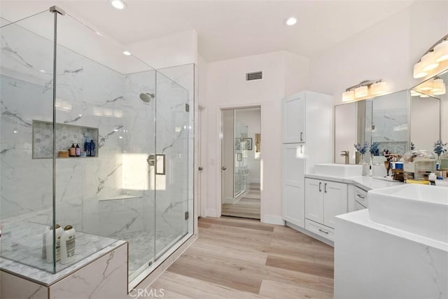 bathroom featuring wood-type flooring, vanity, and a shower with shower door