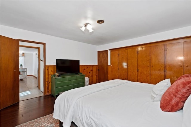 bedroom featuring dark hardwood / wood-style floors and wood walls