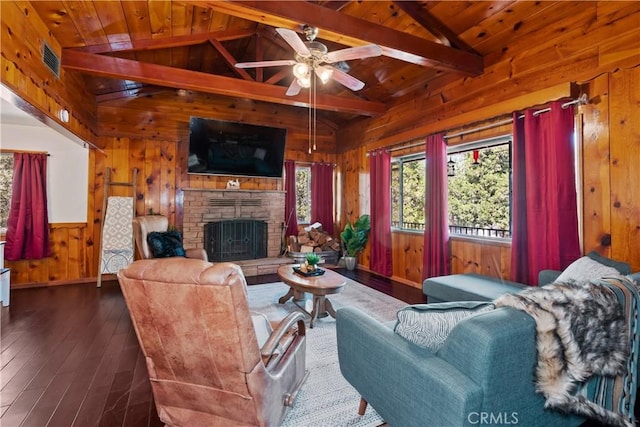 living room with a fireplace, wooden walls, vaulted ceiling with beams, ceiling fan, and dark wood-type flooring