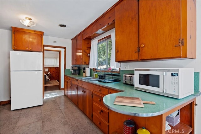 kitchen featuring white appliances and sink