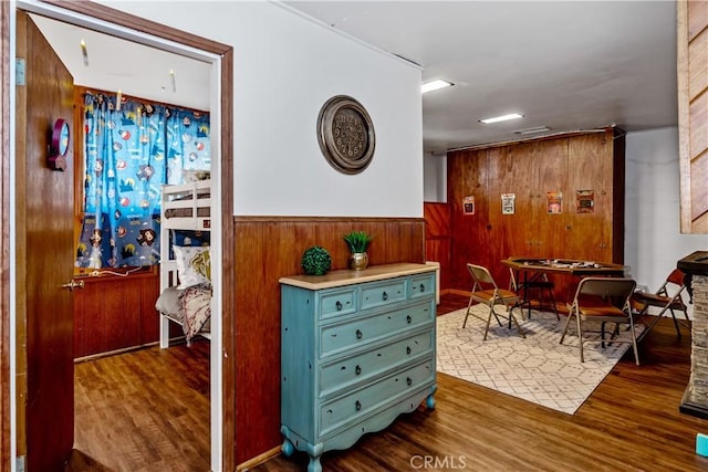 interior space with dark wood-type flooring and wooden walls