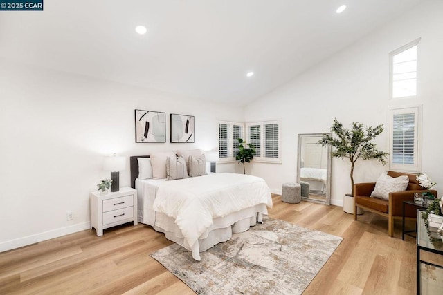 bedroom with high vaulted ceiling and light hardwood / wood-style floors