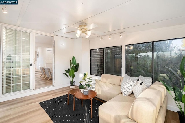 sunroom featuring ceiling fan and plenty of natural light