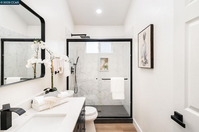 bathroom featuring hardwood / wood-style floors, an enclosed shower, vanity, and toilet