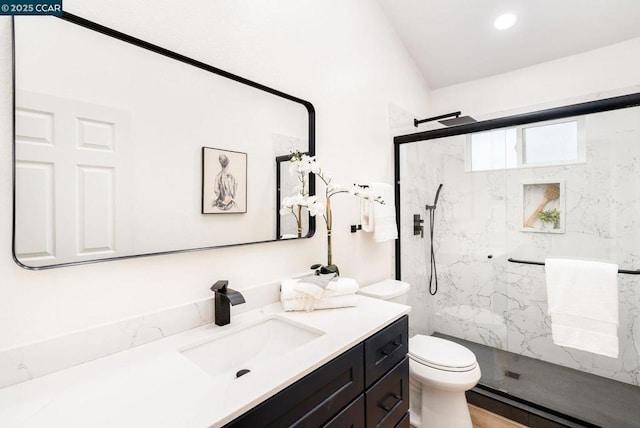 bathroom featuring a shower with door, toilet, and vanity