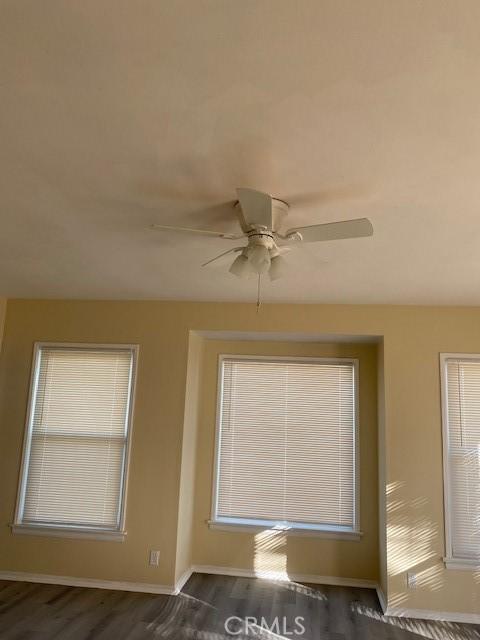 spare room with dark hardwood / wood-style flooring and ceiling fan