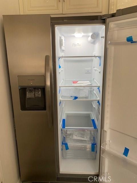 room details featuring white cabinetry and stainless steel fridge