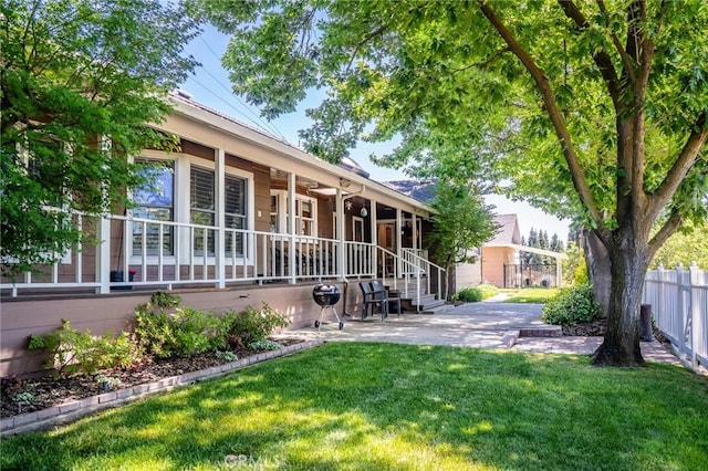 back of house with ceiling fan and a lawn