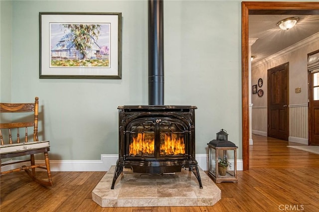 details featuring a wood stove, hardwood / wood-style floors, and ornamental molding