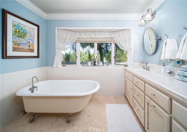 bathroom featuring a bathing tub, tile patterned flooring, crown molding, vanity, and tile walls