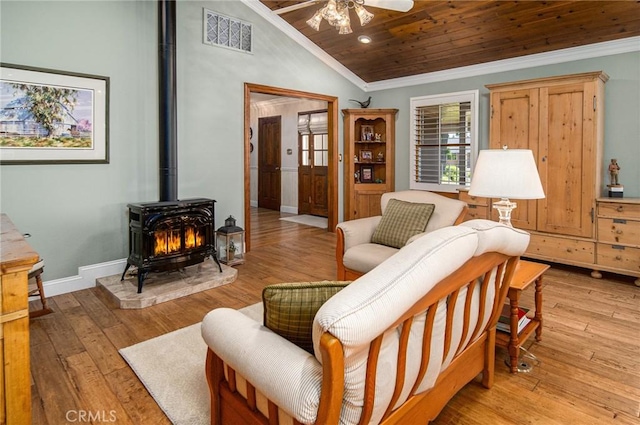 living room featuring light wood-type flooring, wood ceiling, ceiling fan, a wood stove, and lofted ceiling