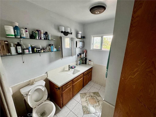 bathroom with toilet, vanity, and tile patterned floors