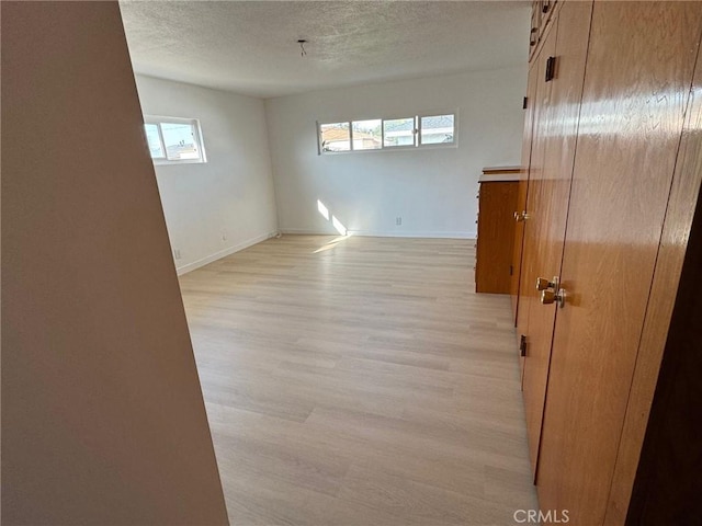 spare room with light hardwood / wood-style flooring and a textured ceiling