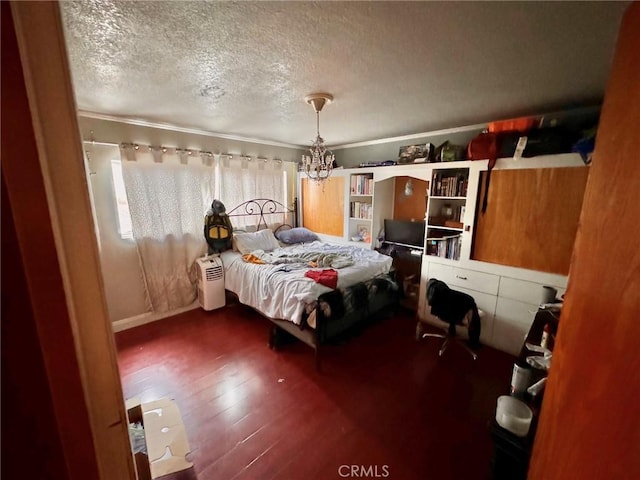 bedroom featuring ornamental molding, wood-type flooring, a textured ceiling, and a notable chandelier