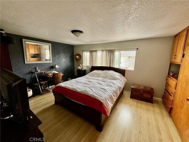 bedroom with light hardwood / wood-style floors and a textured ceiling